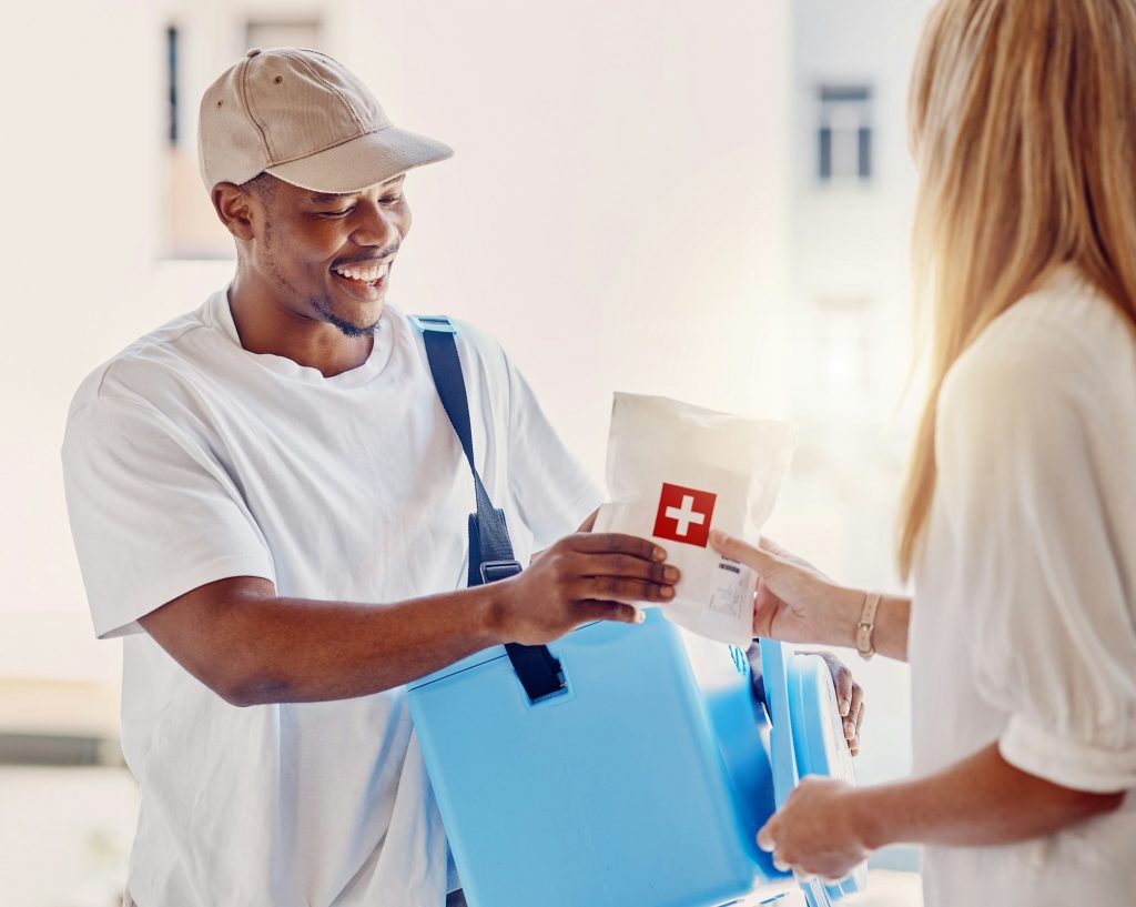 Healthcare, delivery and supply with a courier black man making a delivery to a woman in her home.