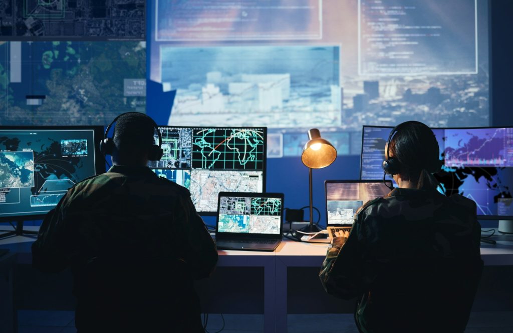 Military control room, computer screen and team with surveillance, headset and tech communication f